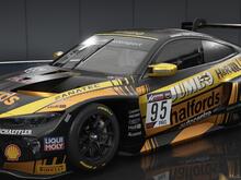 Angled shot of an M4 GT3 showing the front and right side in a black and orange Halfords livery with yellow secondary stripes