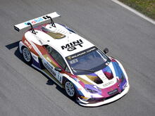In game screenshot of a Lamborghini Huracan GT3 Evo 2 with a colourful metallic voronoi pattern on a white base.
